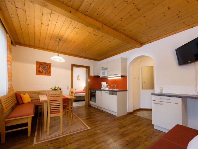 Wohnküche mit Flat-TV und gemütlicher Couch