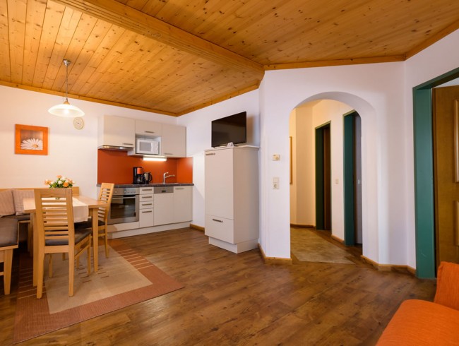 Wohnküche mit Flat-TV, Essecke und gemütlicher Couch